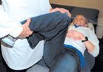 The doctor is forcing internal rotation of the patient's right hip.
